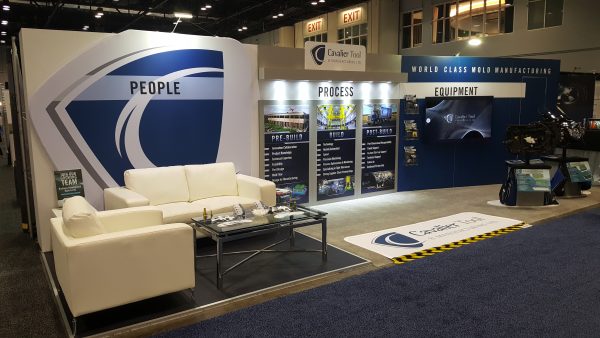 A picture of the Cavalier Booth at NPE 2018. Our motto (People. Process. Equipment.) is displayed in the back along with our logo and infographics explaining our process.
