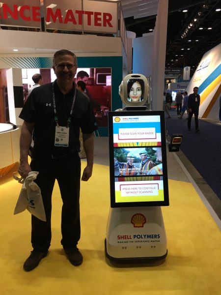 Cavalier Tool and Manufacturing's Plant Manager Larry Caron standing next to a Shell Polymers Robot at NPE 2018.