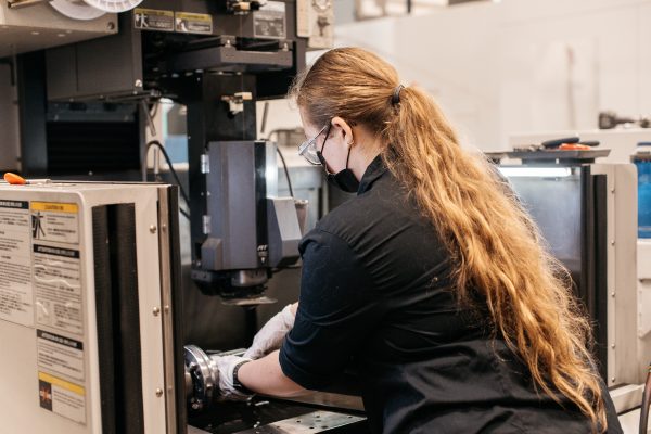 Cynthia Cooper, a pre-apprentice at Cavalier Tool adjusts a part in an EDM Machine at Cavalier's World Headquarters in Windsor Ontario.